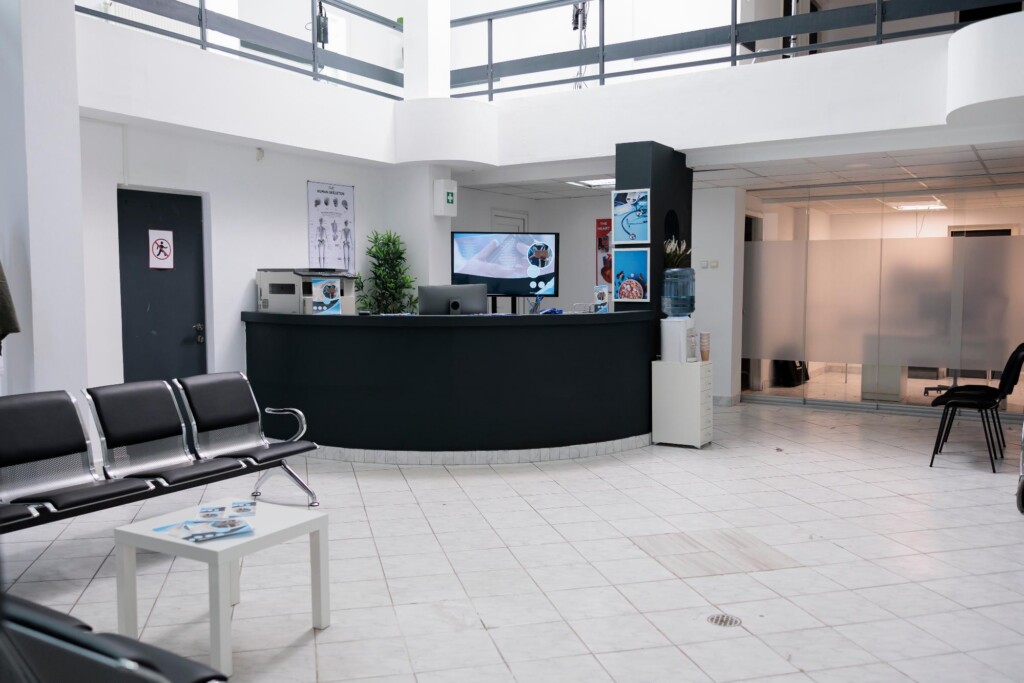 Bright clinic reception area with a front desk and waiting chairs