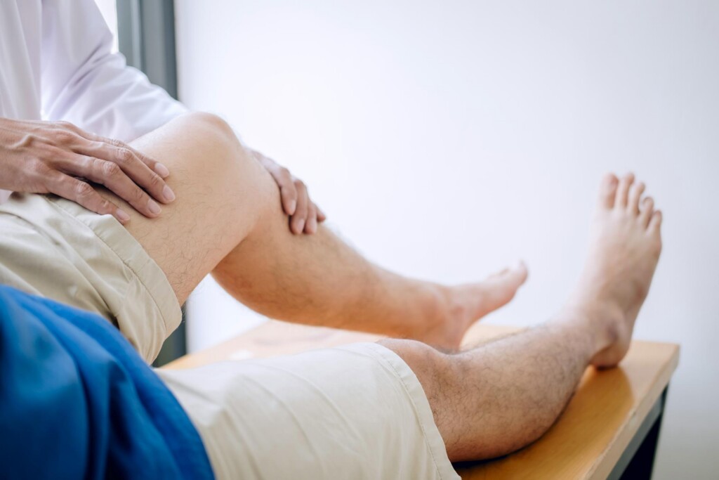 Physician examining a patient's knee for a joint injury