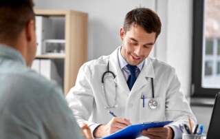Physician taking notes during a car accident injury treatment consultation