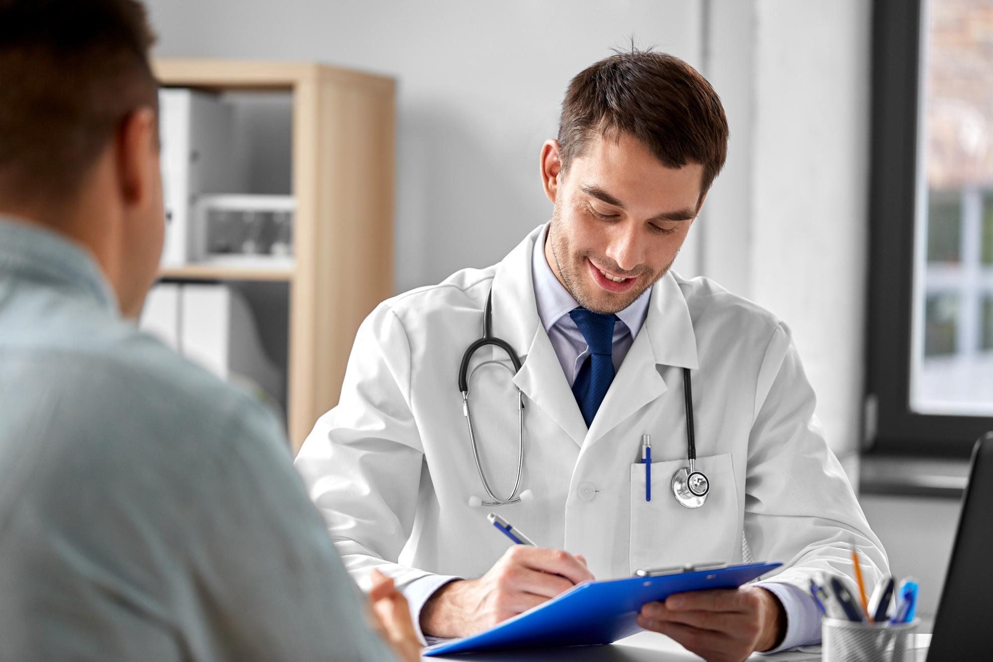 Physician taking notes during a car accident injury treatment consultation